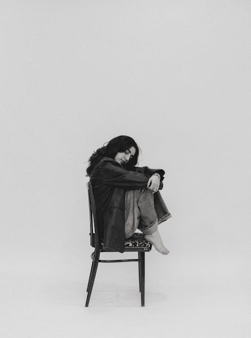 Black and White Photo of a Woman Sitting on a Chair 