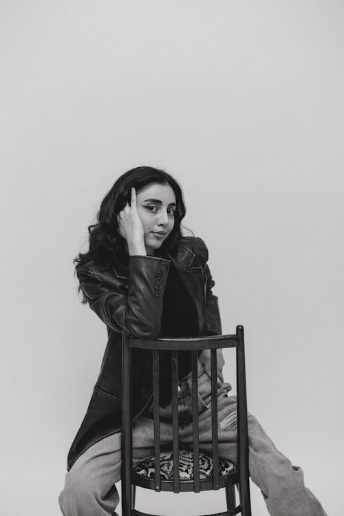 A woman sitting on a chair in black and white