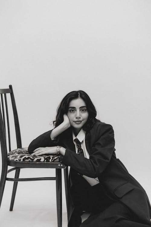 A woman in a suit sitting on a chair