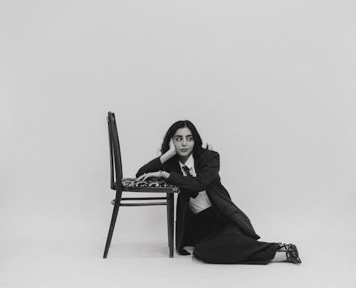 A woman sitting on a chair in front of a black and white photo