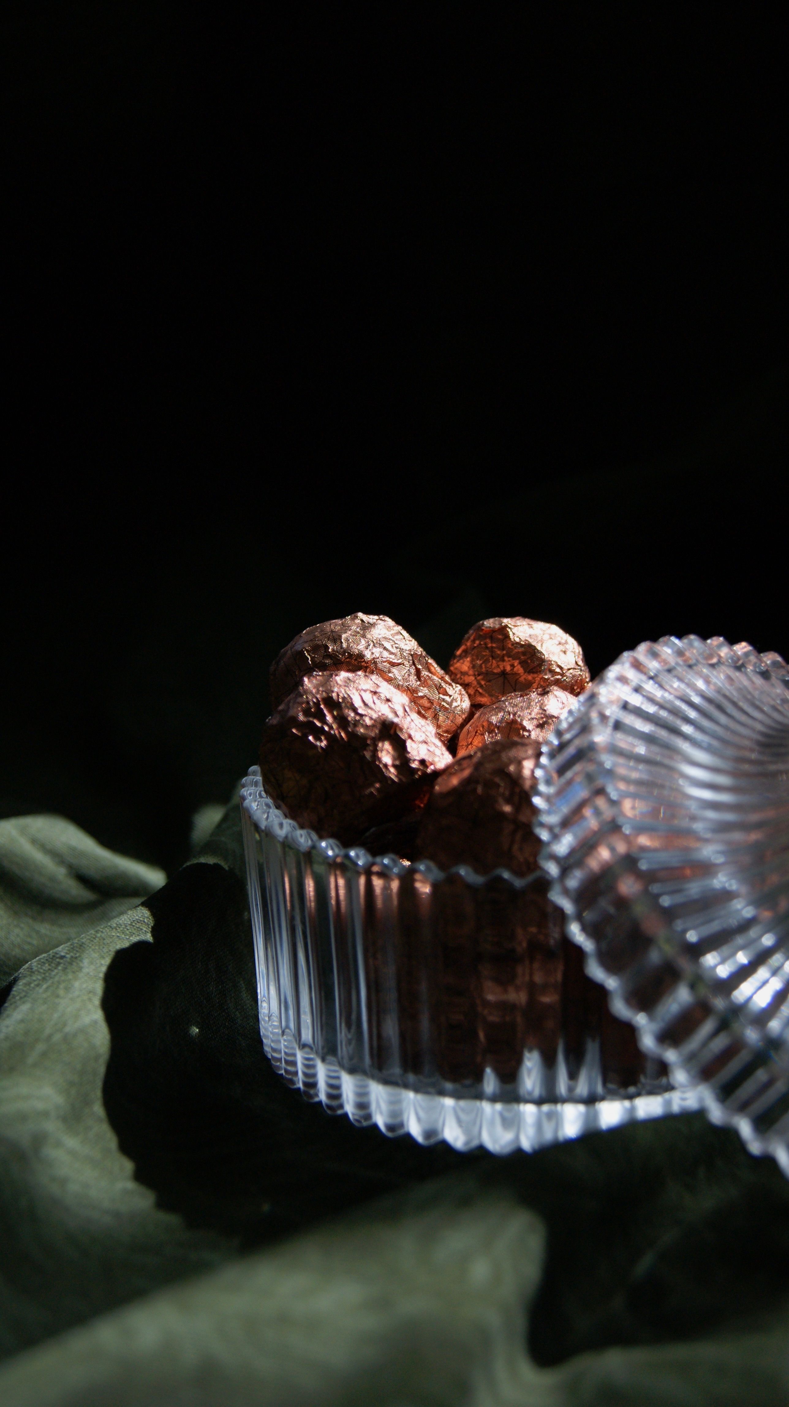 Indulge in premium chocolates presented elegantly in a ribbed glass dish, ideal for gourmet lovers.