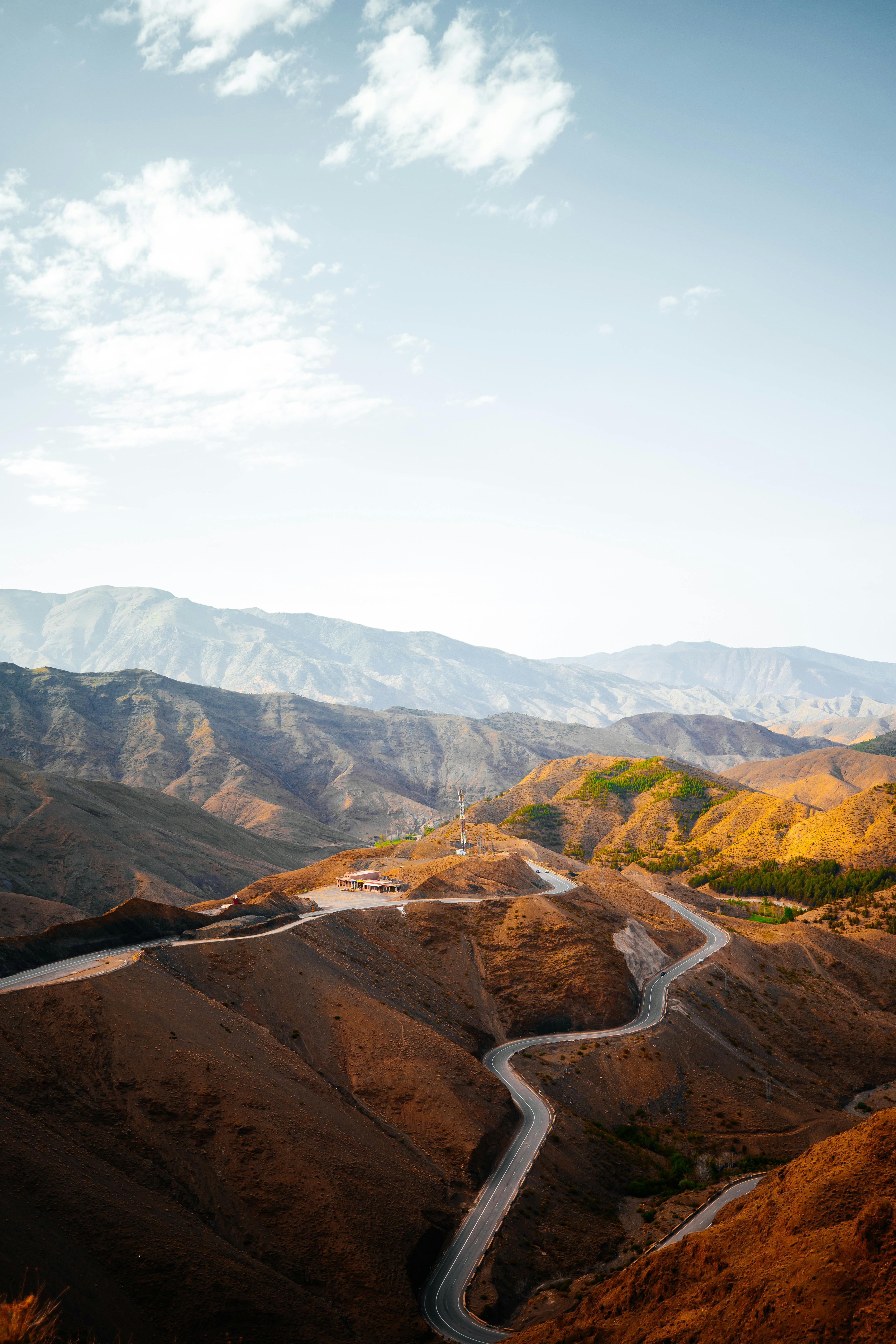 A breathtaking aerial view of a winding road through mountainous terrain, showcasing nature's beauty.