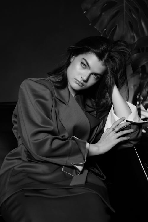 Young Woman in Blazer Sitting with Her Head Rested on Her Hand