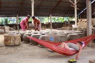 孩子在吊床上休息，工匠在传统作坊里制作陶器