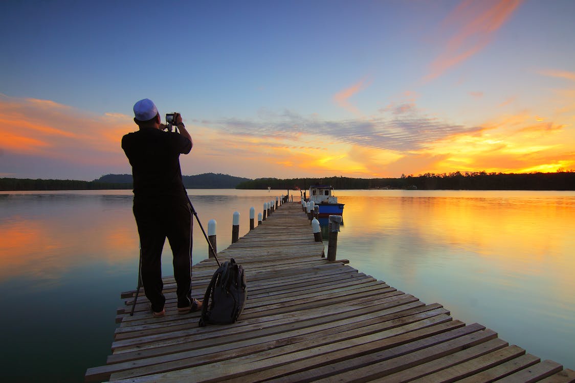 Free Man Points Camera at Golden Hour Stock Photo