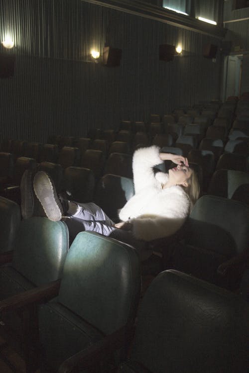 A person laying down in a theater