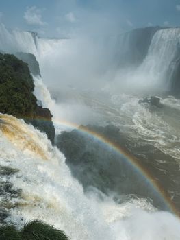 Iguazu Falls captured in full splendor with a bright rainbow, showcasing nature's beauty.