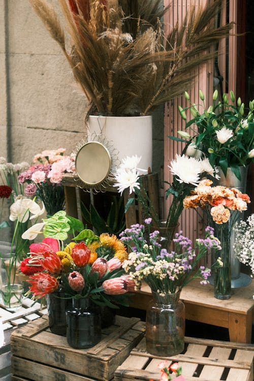 A flower stand with vases and flowers on it