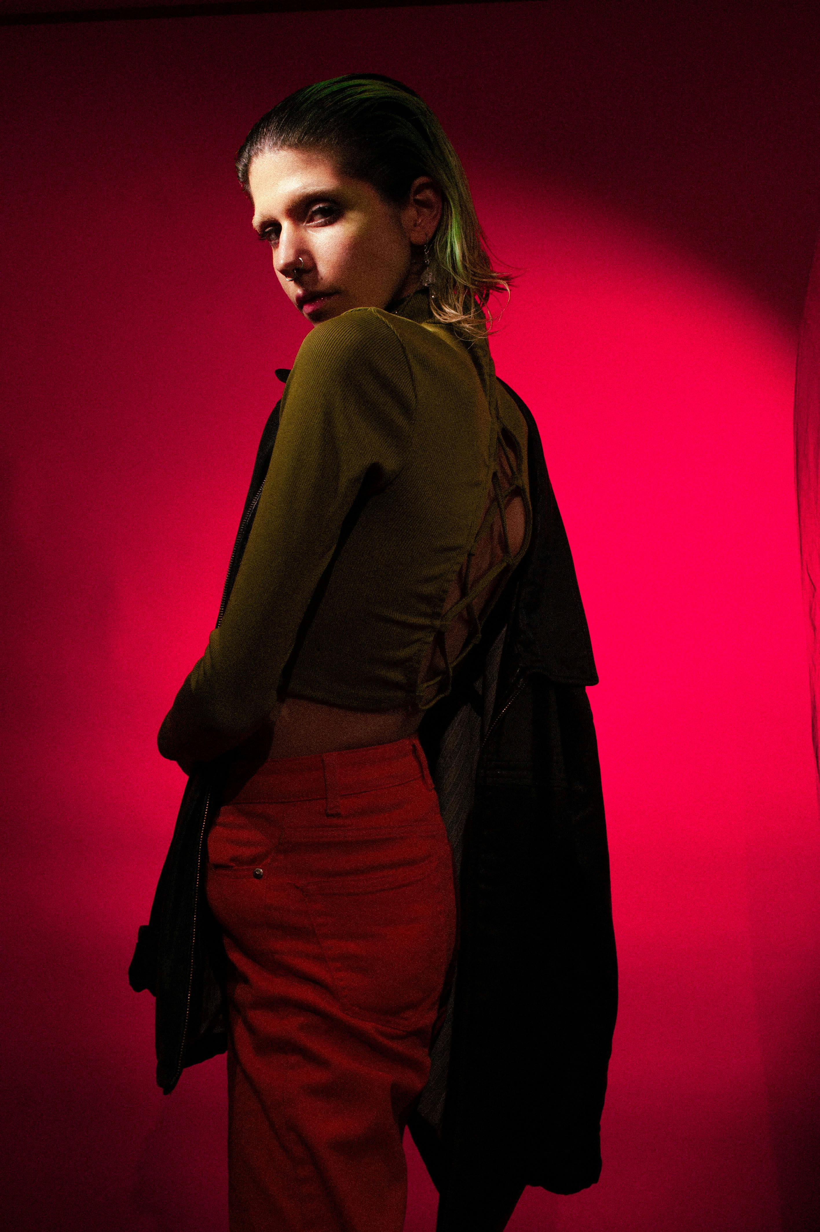 grátis Mulher Em Pé Sobre Fundo Vermelho Foto profissional