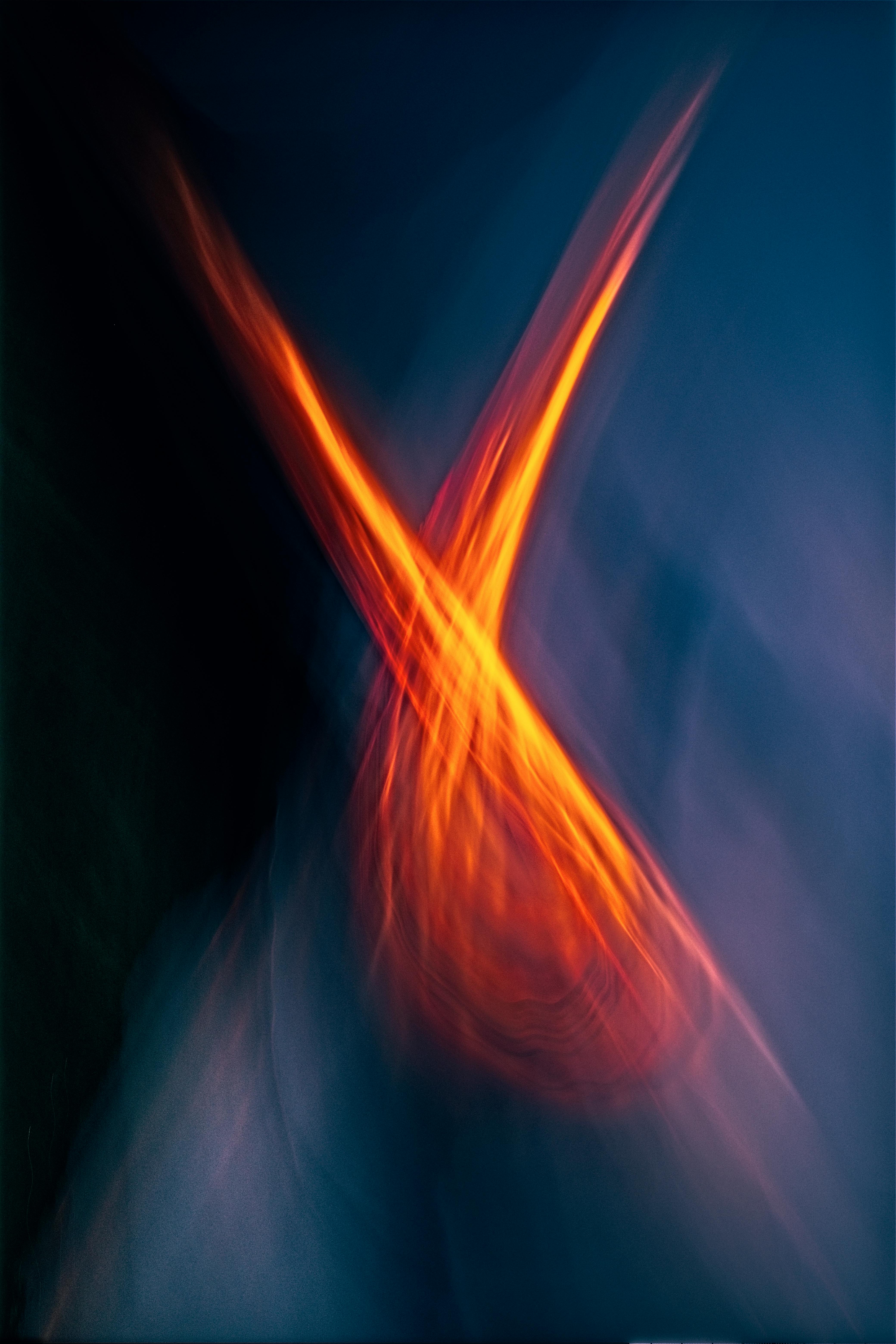 Dynamic abstract image with vibrant orange streaks on a deep blue background.