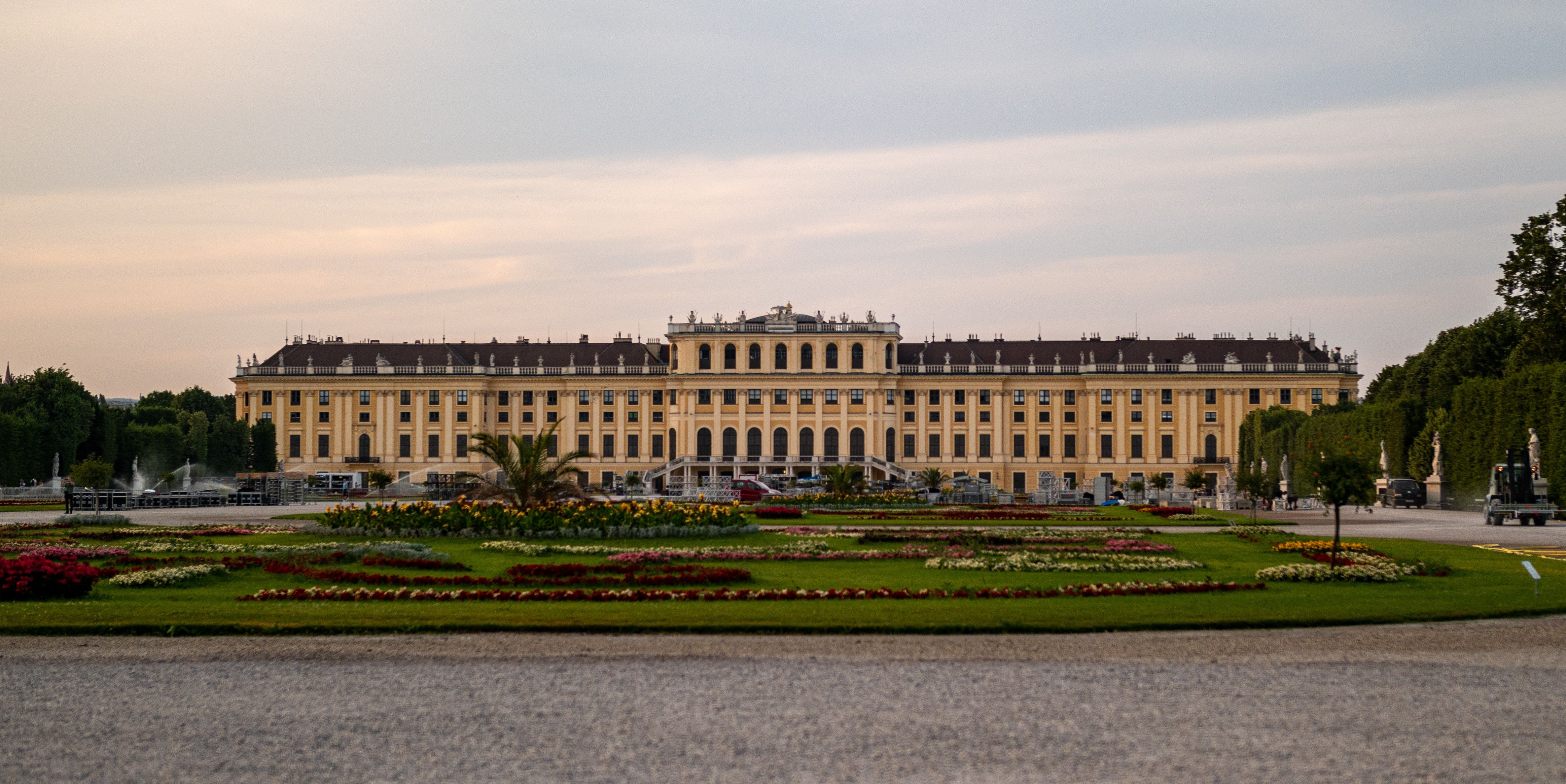 Elegant view of Schonbrunn Palace in Vienna, Austria, with vibrant gardens at dusk.
