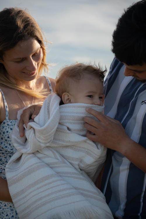 Free A family holding a baby wrapped in a blanket Stock Photo