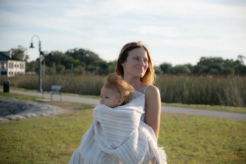 Free A woman holding a baby in a wrap Stock Photo