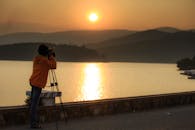 摄影师在宁静的湖边捕捉美丽的日落剪影