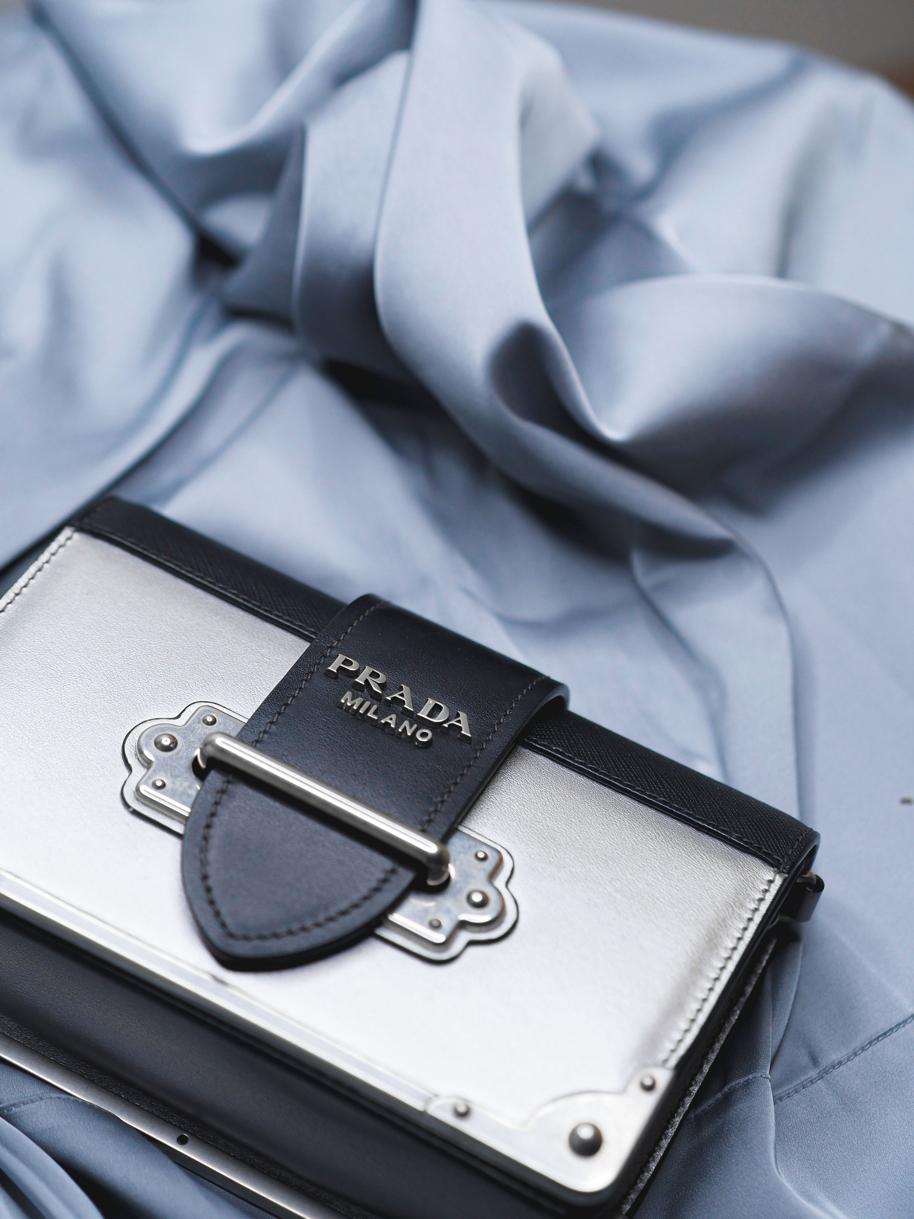Bolsa de grife Prada em fundo de tecido elegante, destacando a moda de luxo.
