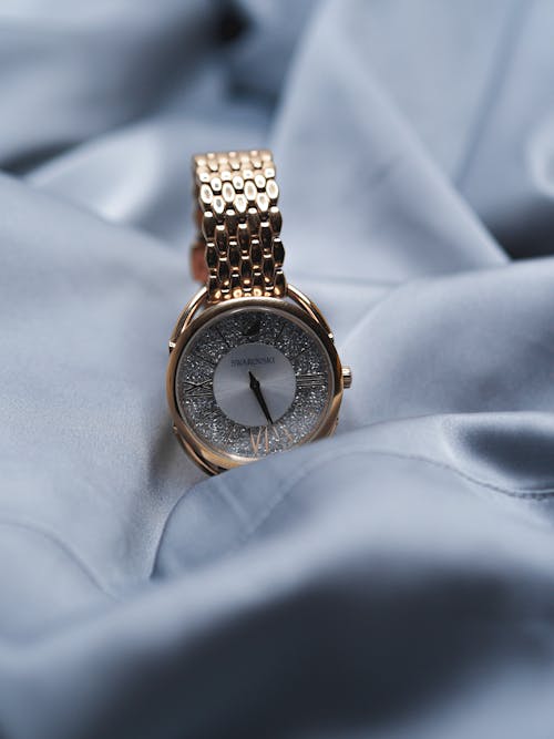 A gold watch on a blue cloth