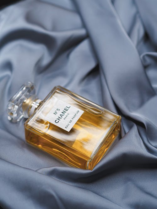 A bottle of chanel perfume sitting on a blue cloth