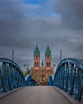 Moody skies over a bridge leading to St. John's Church in Freiburg, Germany.