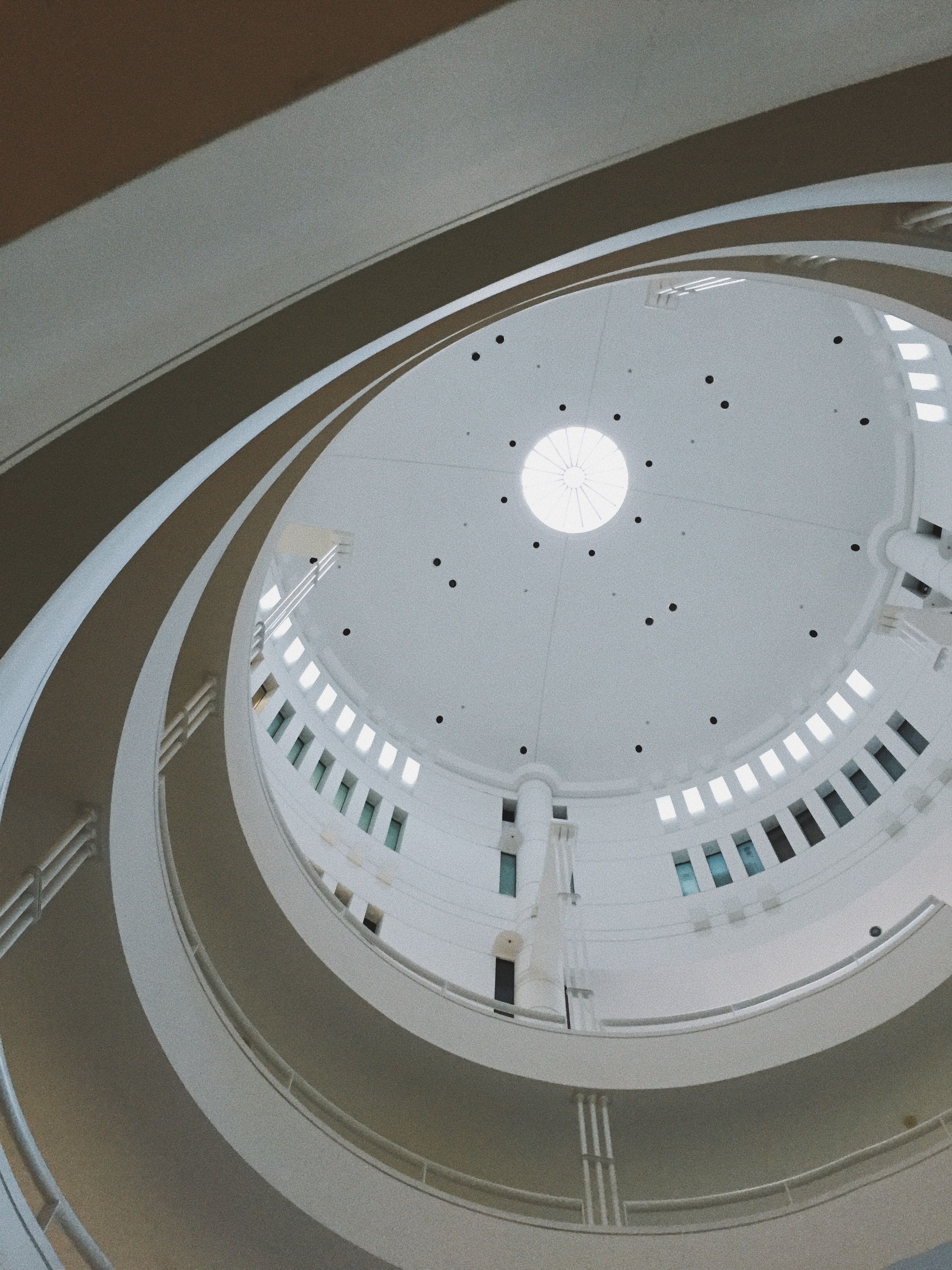 The inside of a circular building with a white ceiling · Free Stock Photo