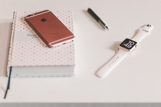 A minimalist desk featuring a smartwatch, smartphone, pen, and notebook for tech-savvy professionals.