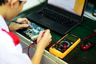 技术人员在专业工作区用笔记本电脑配合万用表工作