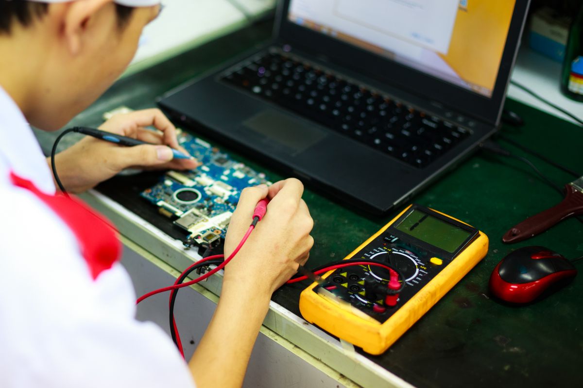 Techniker bei der wirtschaftlichen Prüfung und Reparatur eines Laptops