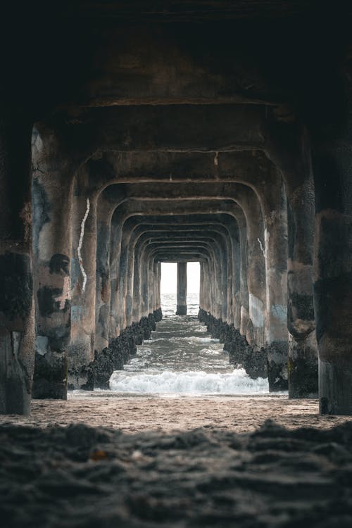 The beach is under an old pier