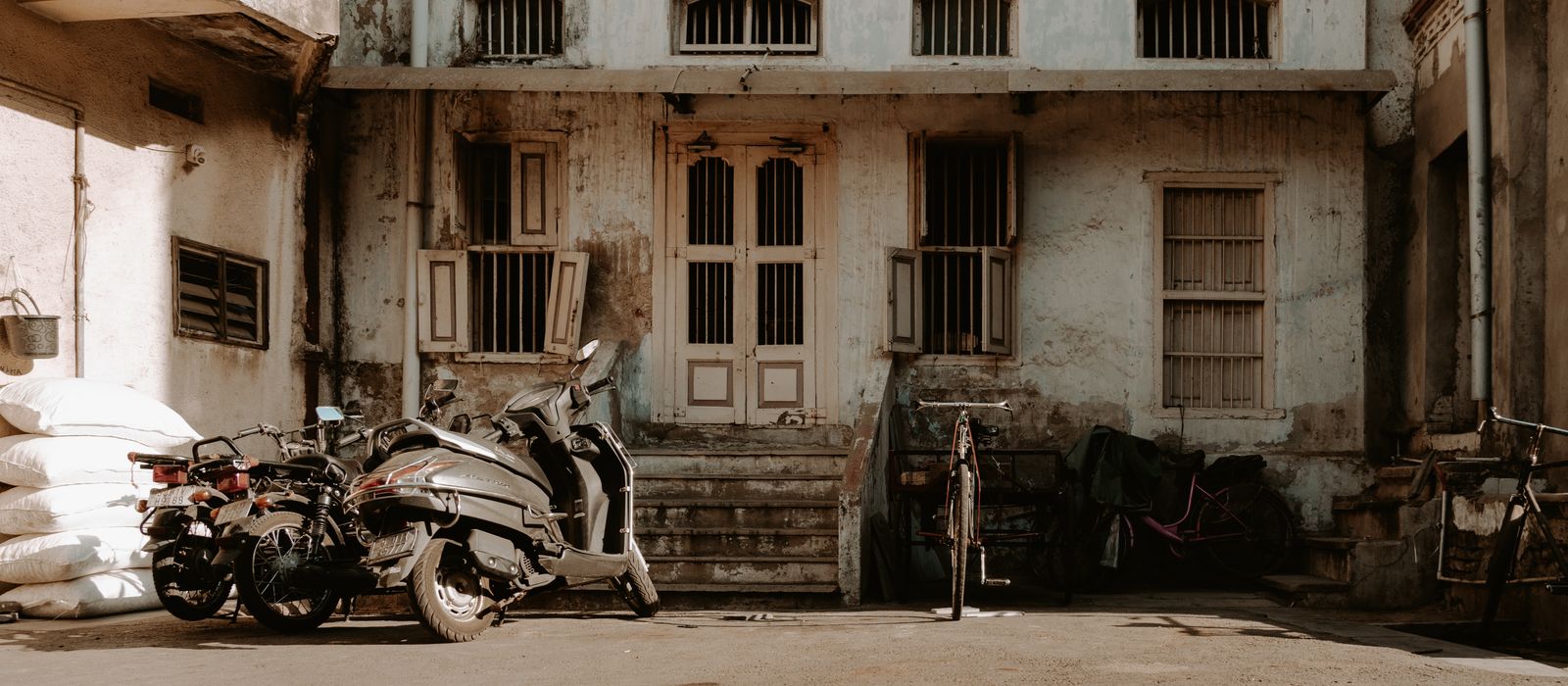Urban scene showing an abandoned building and motorcycles in Ahmedabad, India. — flights from Kuwait City to Ahmedabad
