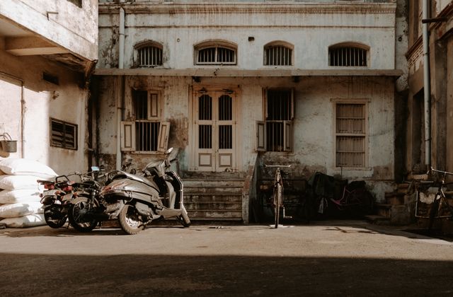 Urban scene showing an abandoned building and motorcycles in Ahmedabad, India. — arriving in Ahmedabad