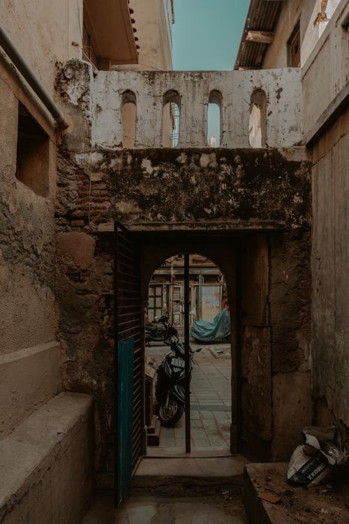 Free An old stone gate revealing a rustic alleyway in Ahmedabad, India. Stock Photo