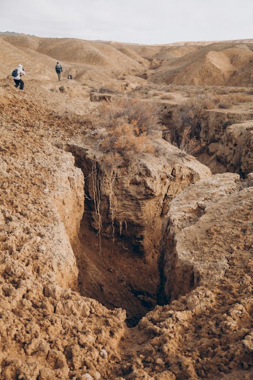 A person standing in a hole in the desert