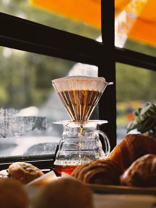 Free A coffee maker is sitting on a table next to some croissants Stock Photo