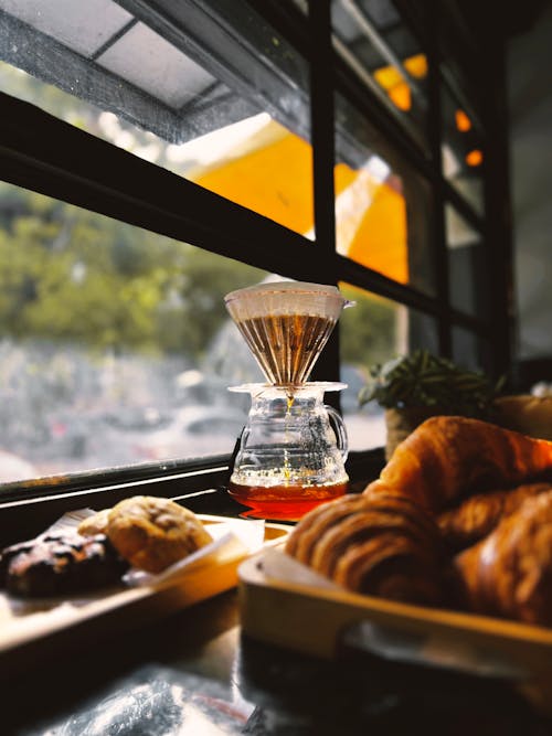 Free A coffee maker sits on a table next to a window Stock Photo