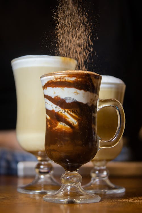 Cappuccino e Chocolate quente com cacau em xícara de vidro