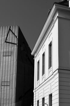 A striking contrast of modern and classic architecture in an urban setting.