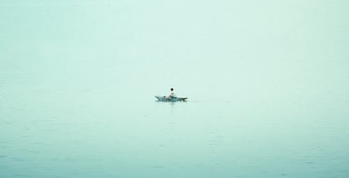 A person in a small boat on a calm lake