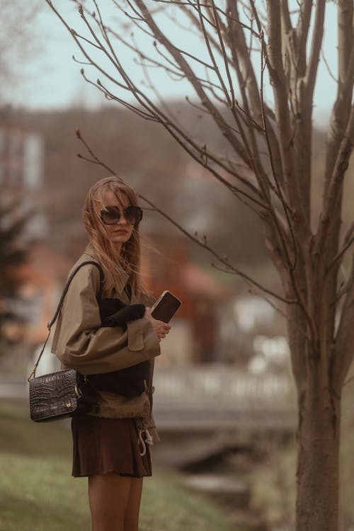 akıllı telefon, ayakta, çıplak ağaca içeren Ücretsiz stok fotoğraf