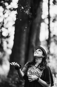 Young woman in Wayanad, India, delighting in nature wearing a hat. Black and white photo.
