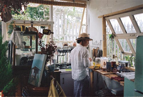 A woman standing in a kitchen with a hat on