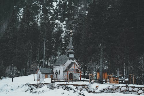 A small church in the snow surrounded by trees
