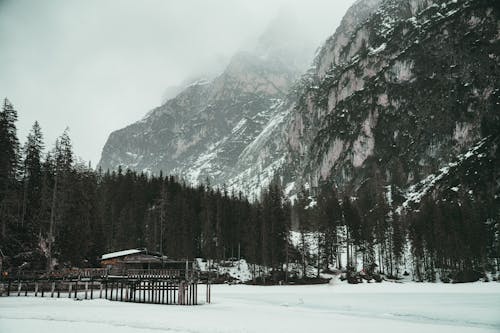 A snowy mountain with a wooden cabin in the background