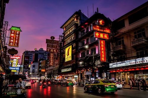 Free Colorful illuminated signs light up Bangkok's Chinatown street at dusk, showcasing urban life and culture. Stock Photo