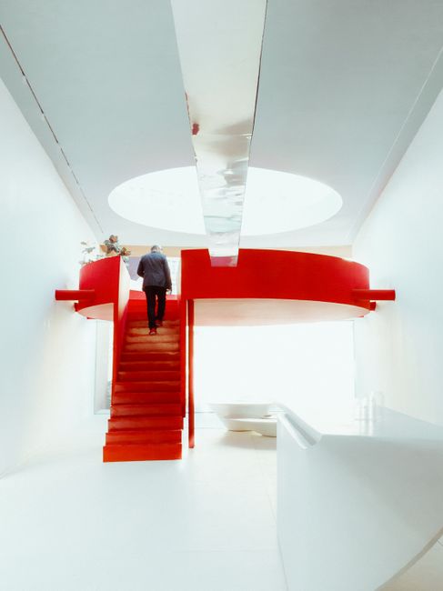 Sleek modern interior featuring vivid red stairs and minimalist design elements.
