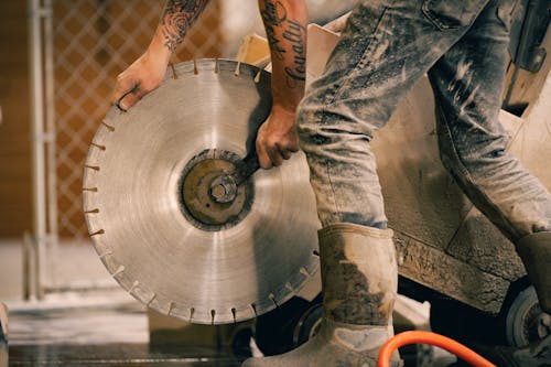 A man is cutting a large circular blade