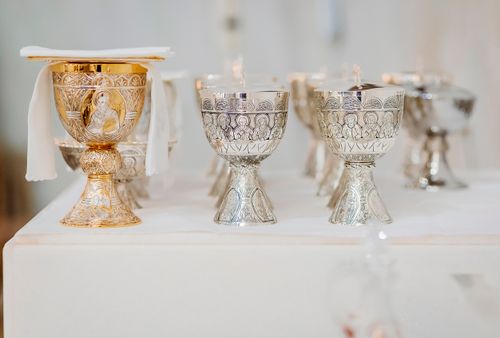 Free Ornate chalices on a table during a religious ceremony, symbolizing Christian traditions. Stock Photo