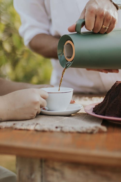 Free A person pouring coffee into a cup with a cake on top Stock Photo