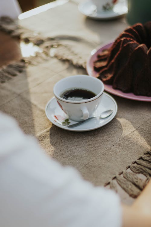 A person is sitting at a table with a cup of coffee