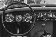 Close-up of a classic MG MGA car interior focusing on the dashboard and steering wheel.