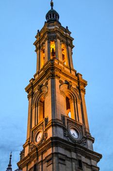 A beautifully illuminated church bell tower in Zaragoza, Spain captured at twilight.