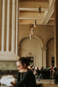 People sitting inside a stylish café with grand architectural columns and warm lighting in São Paulo, Brazil.